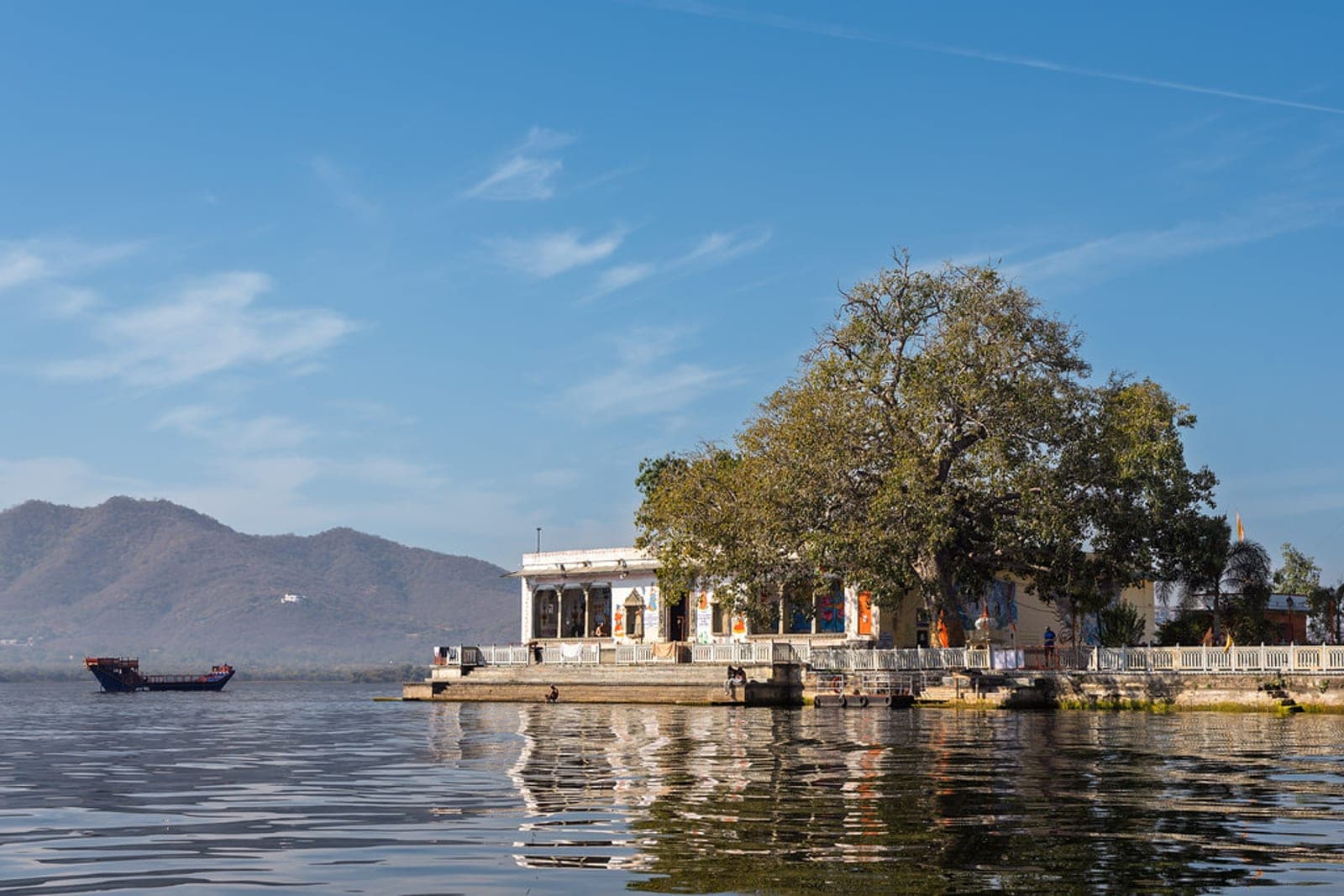 Lake Pichola at dusk with the city palace lit behind it